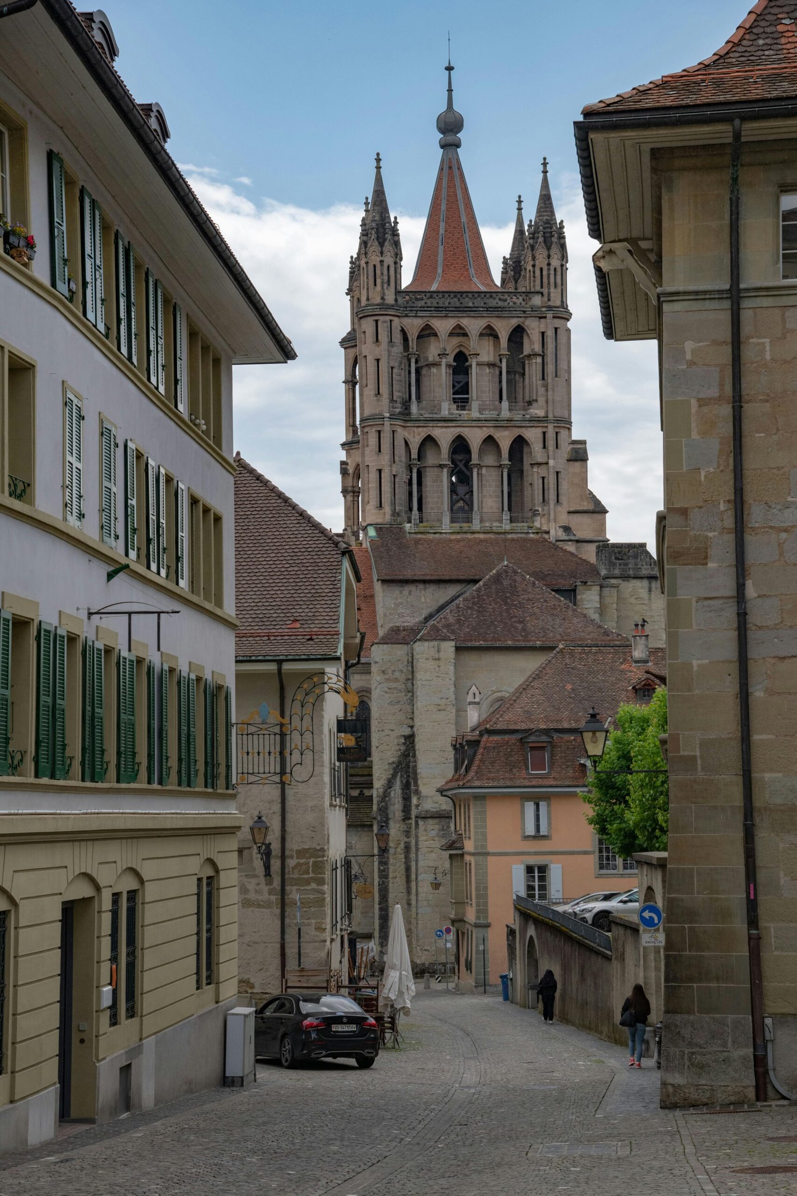 Traducteur-interprète à Lausanne — ruelle pavée de la vieille ville avec la cathédrale, LESINTERPRETES agence certifiée Confédération suisse